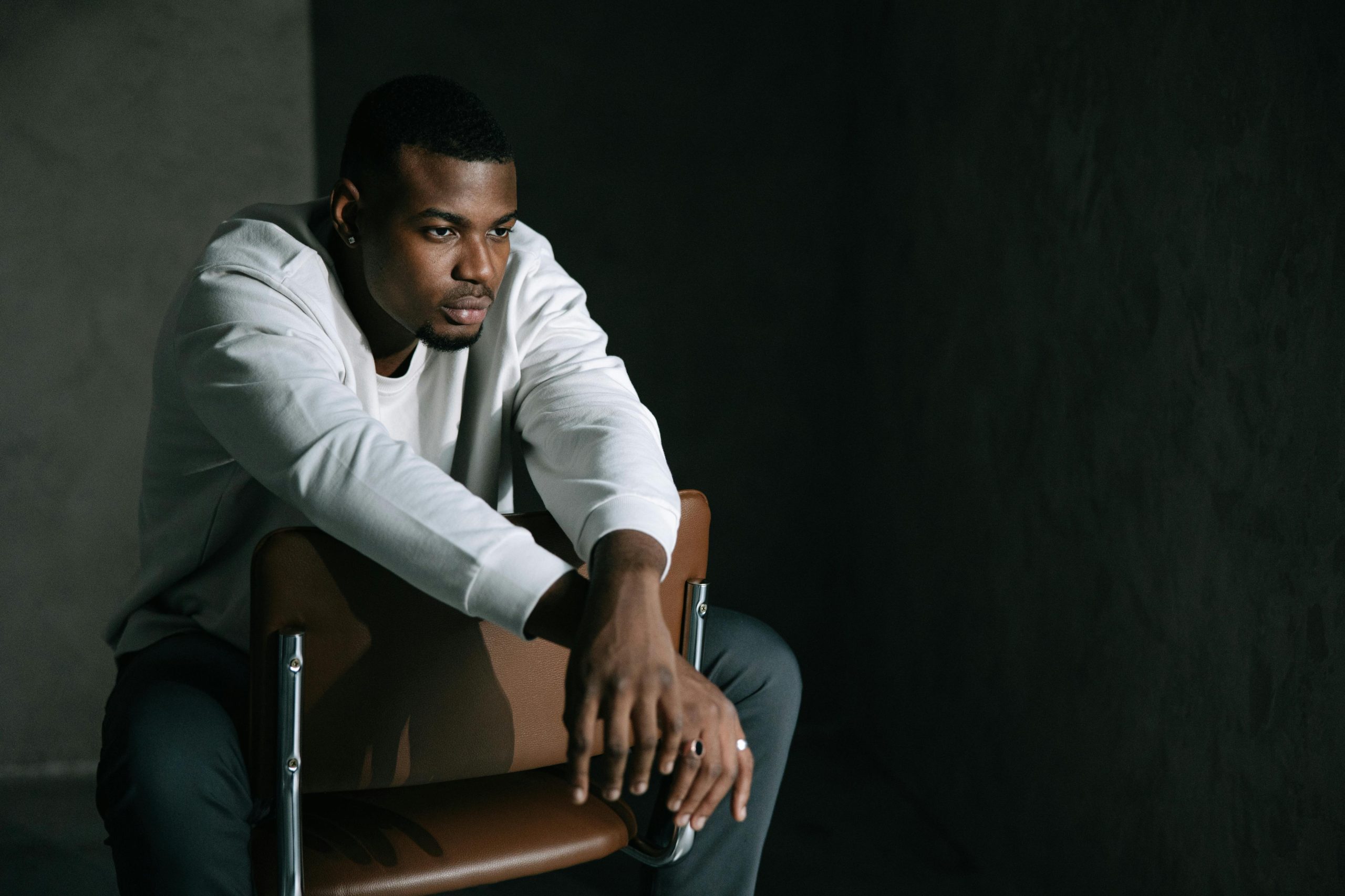 Man sitting in chair in deep thought feeling depressed